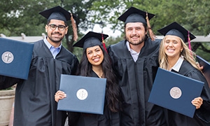 DBU graduates holding their degrees on DBU campus
