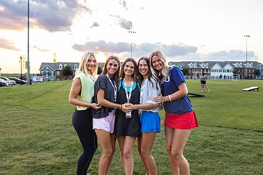 college girls standing outside during the Summer in Dallas, Texas with sunset behind them