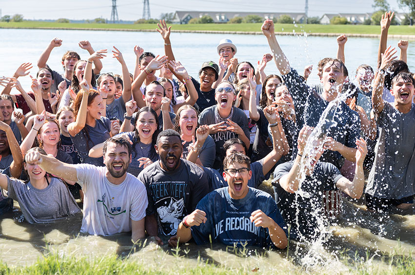 group of DBU students playing in one of the ponds on campus