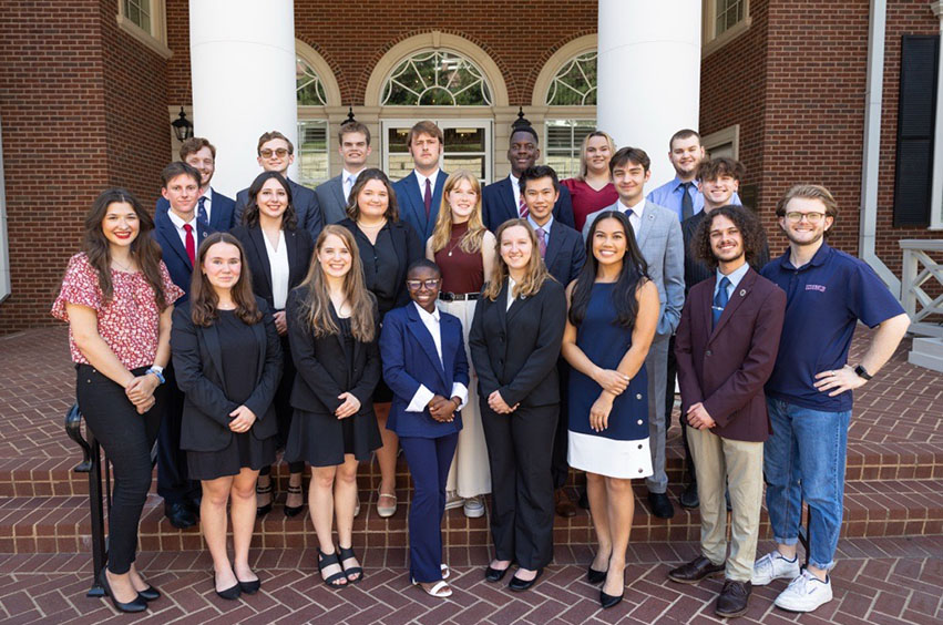 Group photo of the DBU Debate Team standing on stairs outside